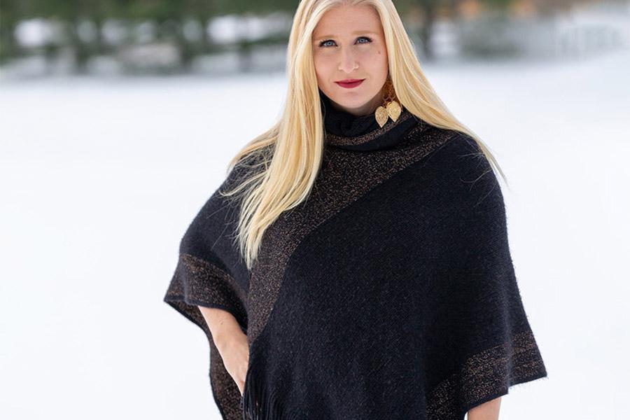 Mulher balançando um poncho preto