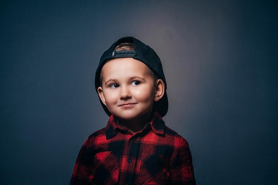 Young boy wearing a red and black plaid shirt