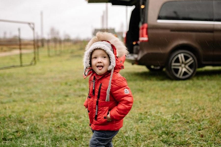 Young boy wearing a red puffer jacket outdoors