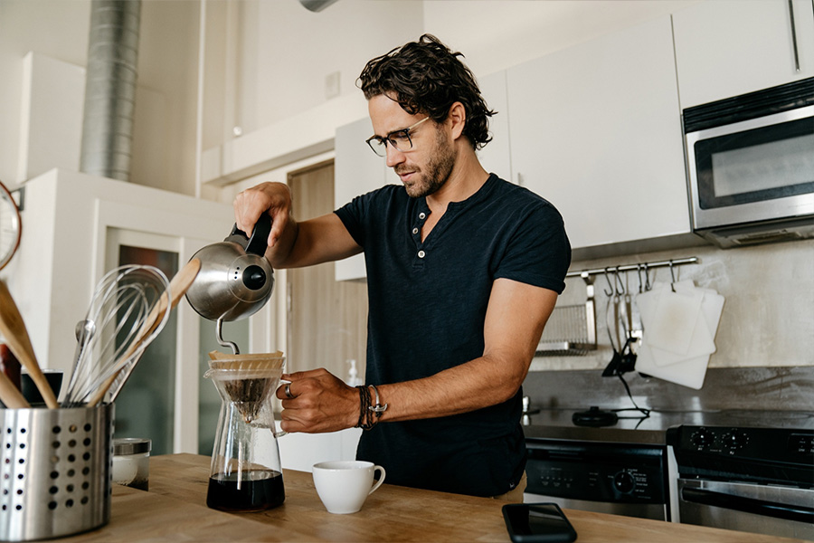 Seorang pria menggunakan gelas beaker untuk membuat kopi