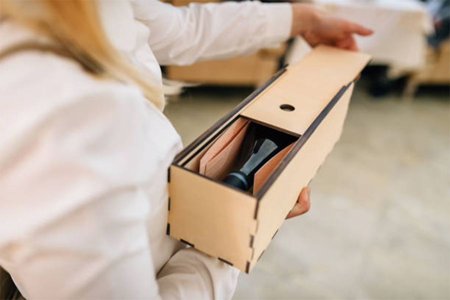 Bamboo wine box being opened with bottle lying inside