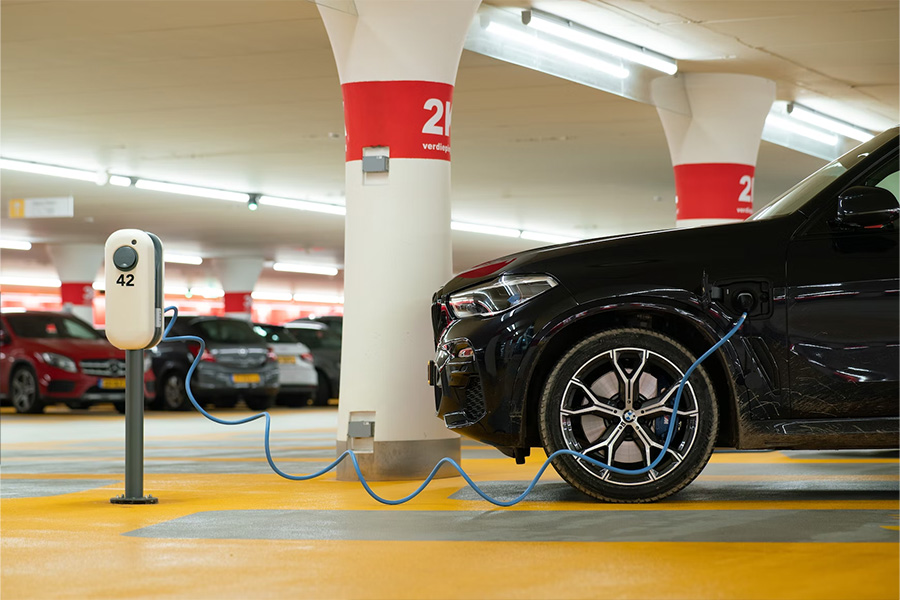 Coche eléctrico negro cargando dentro de un garaje subterráneo