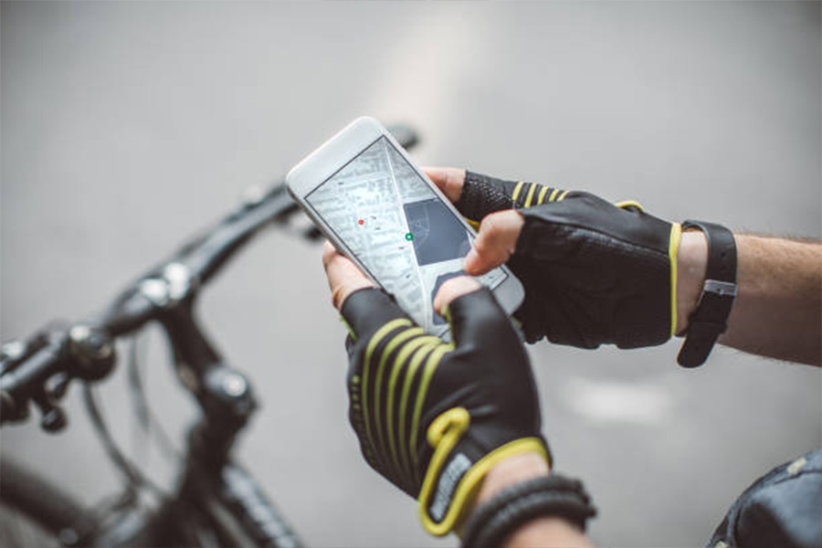 Cyclist holding a mobile phone in hands before mounting it