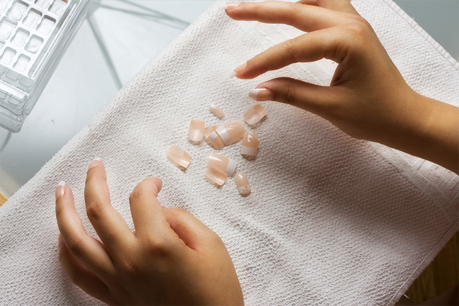 Mains d'une personne appliquant des ongles pressés