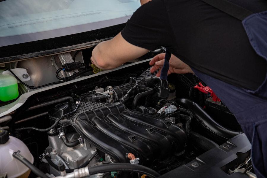 Hombre revisando el motor de un auto