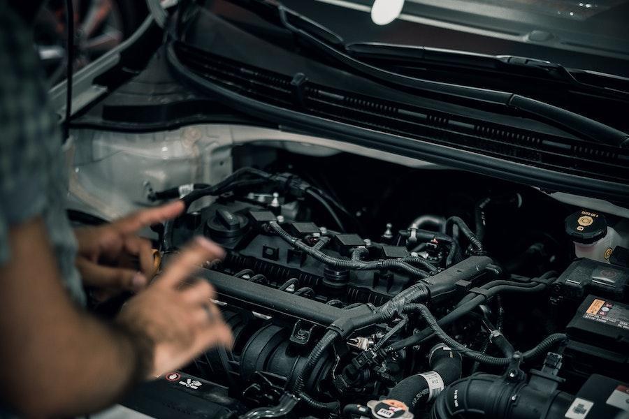 Hombre diagnosticando un motor de automóvil