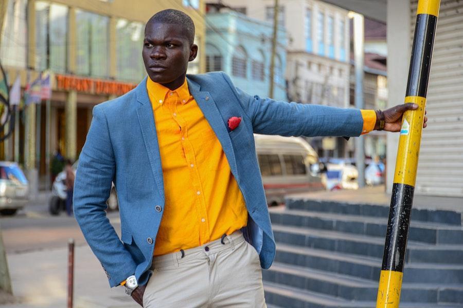 Hombre sujetando un poste con un blazer azul claro