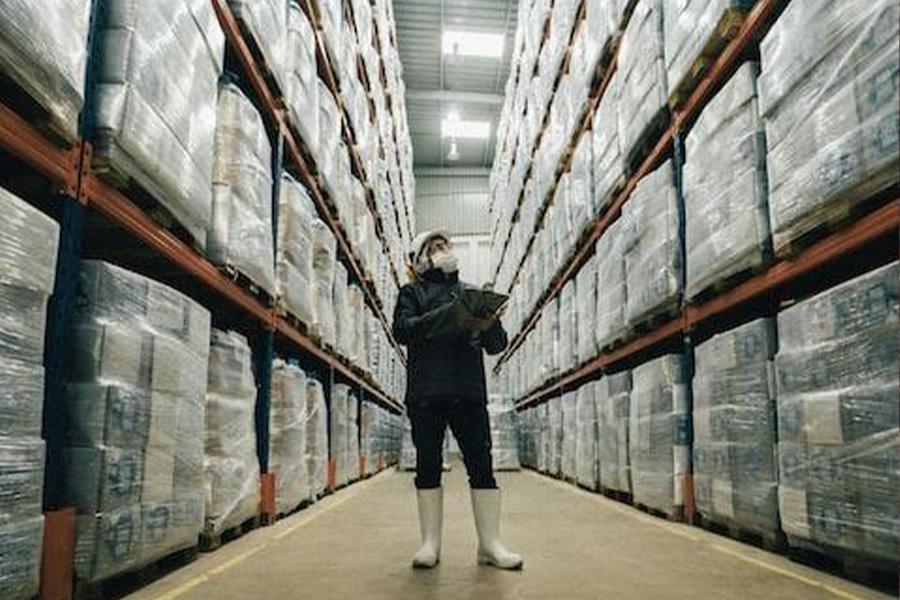 Homme inspectant et enregistrant les informations stockées sur les produits