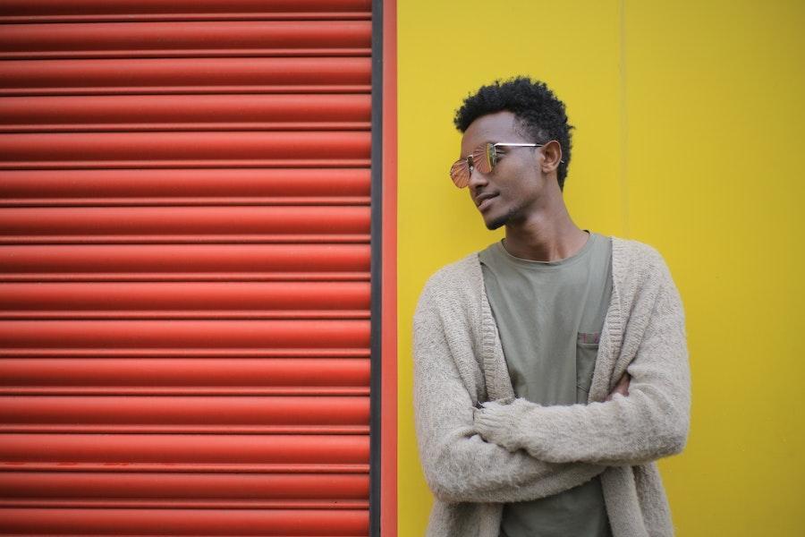 Homme souriant et croisant les bras dans un cardigan texturé crème