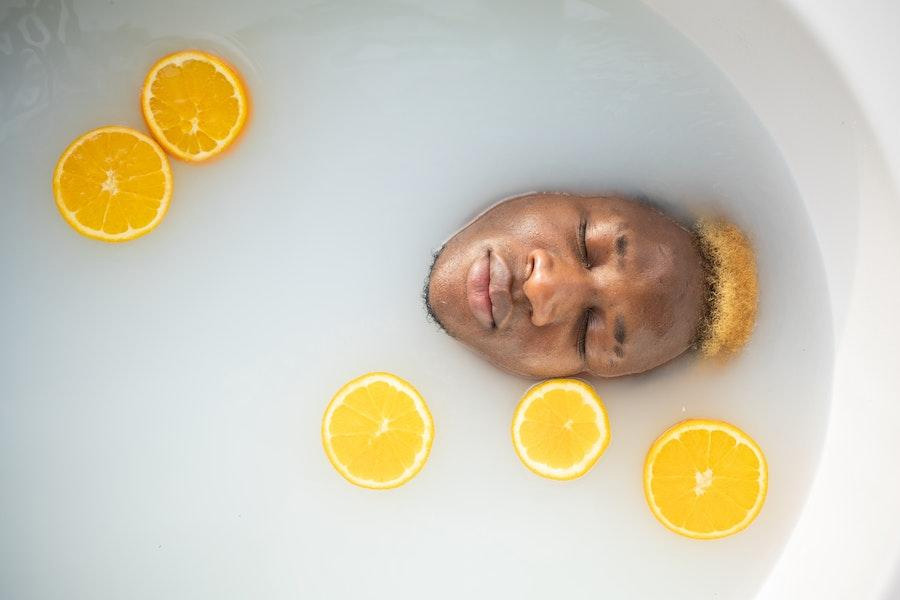 Uomo immerso in un bagno con i limoni