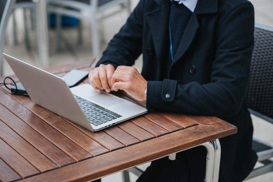 Man wearing a tech jacket while using a laptop