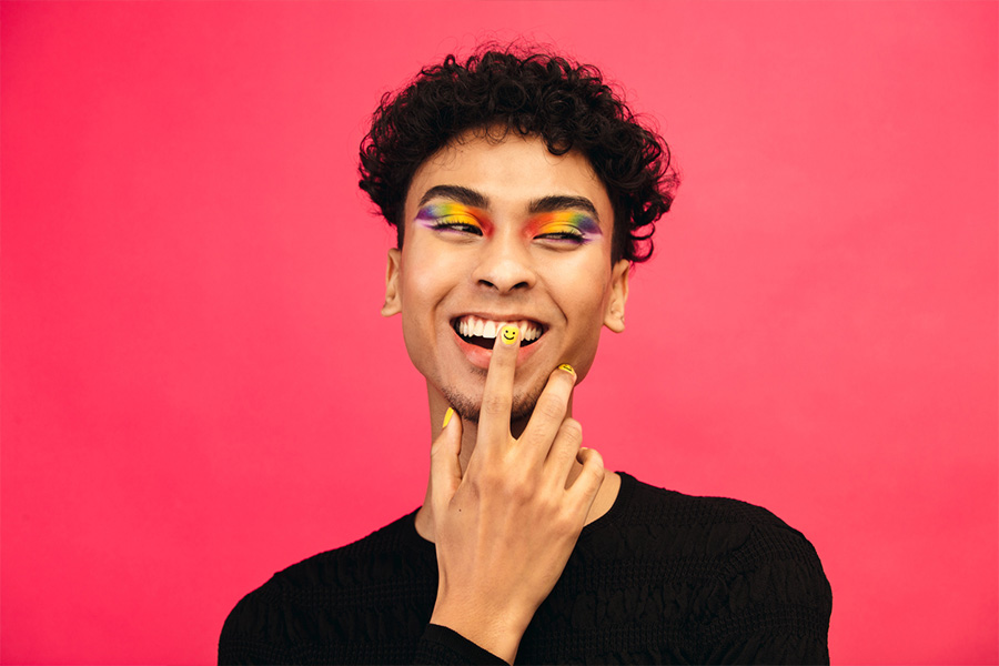 Homme souriant avec nail art coloré