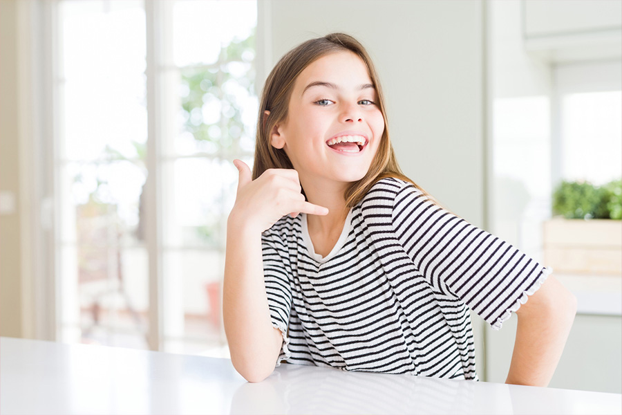 Niña sonriente con una camiseta de hombros caídos