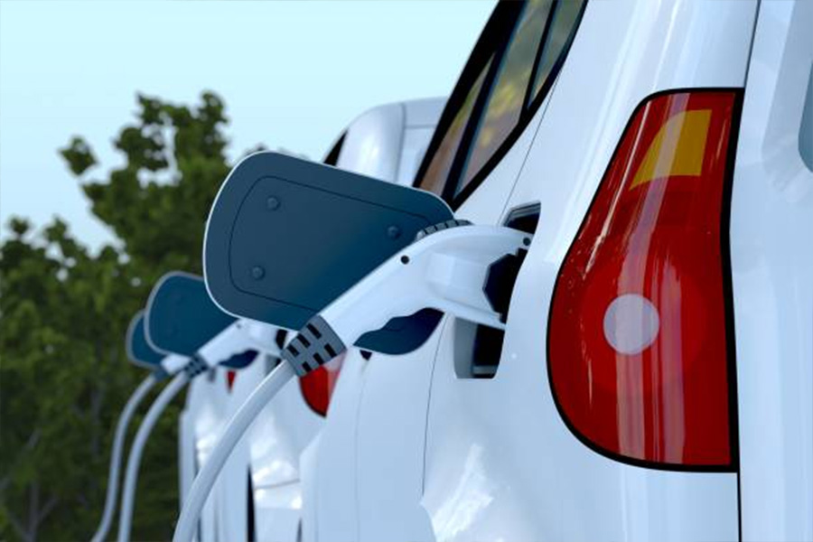 Tres autos eléctricos blancos alineados en la estación de carga