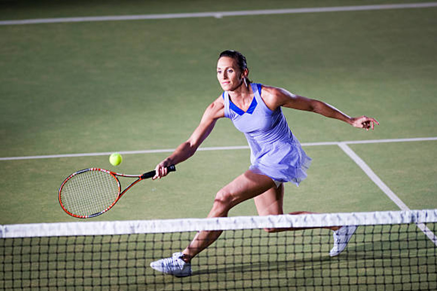 Donna in un vestito da tennis viola sul campo