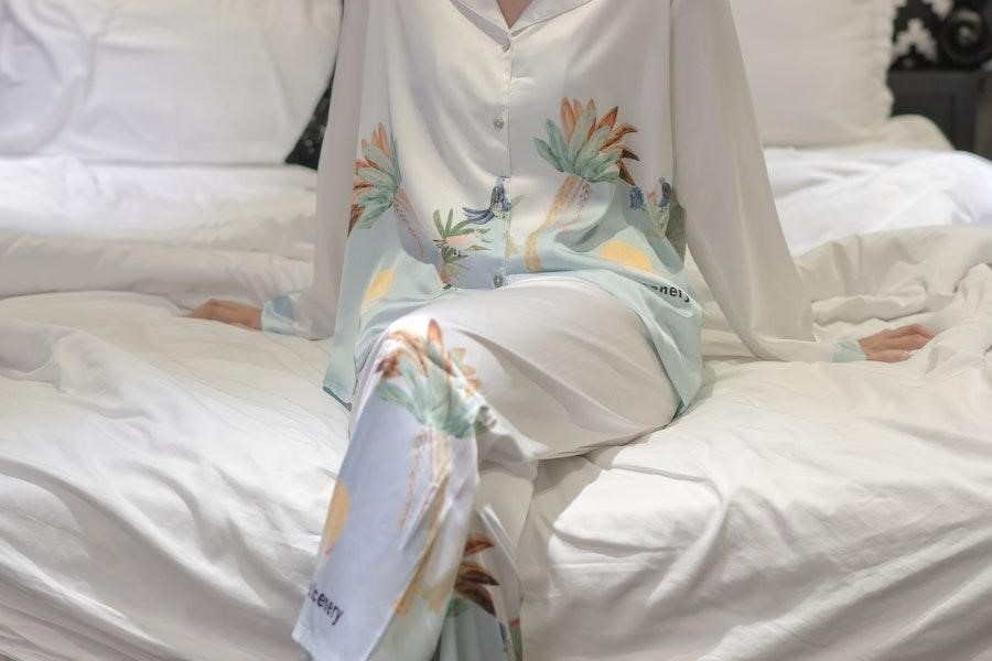 Mujer sentada en una cama con un juego de salón con estampado de flores