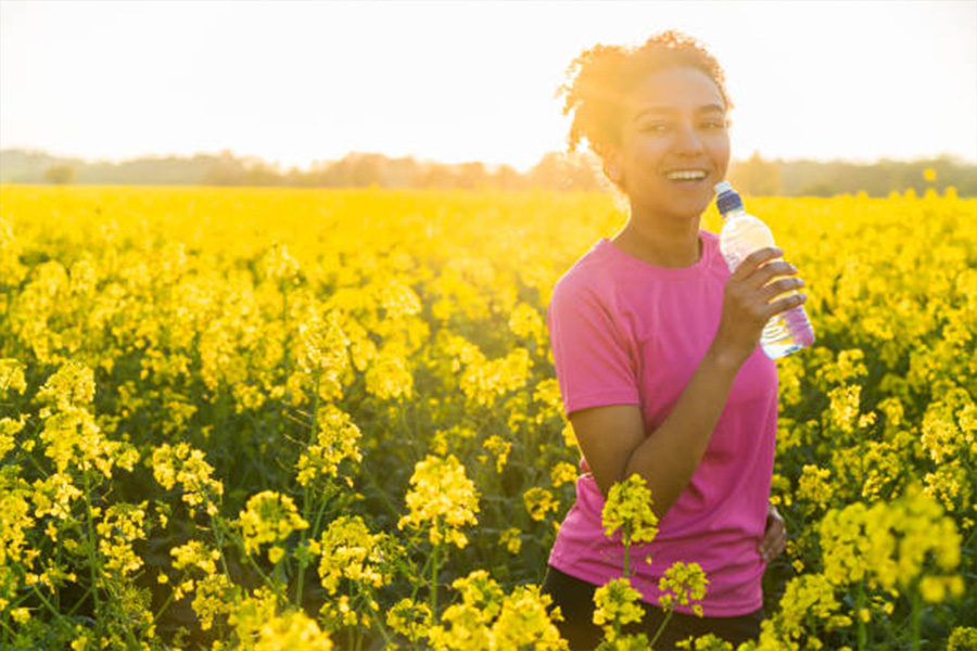 Mulher vestindo uma camiseta rosa em um campo de flores