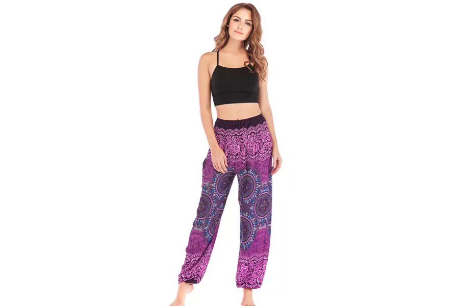 Woman wearing purple psychedelic flowy trousers with patterns