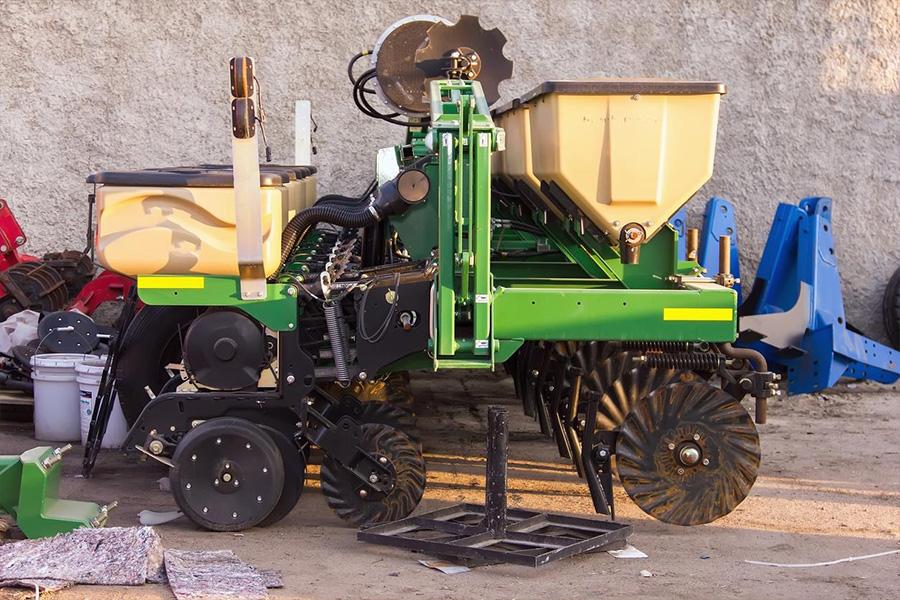 Sembradora agrícola aparcada en un garaje.