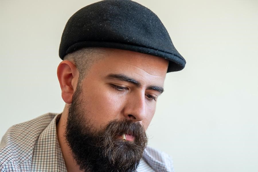 Bearded man rocking a black flat hat