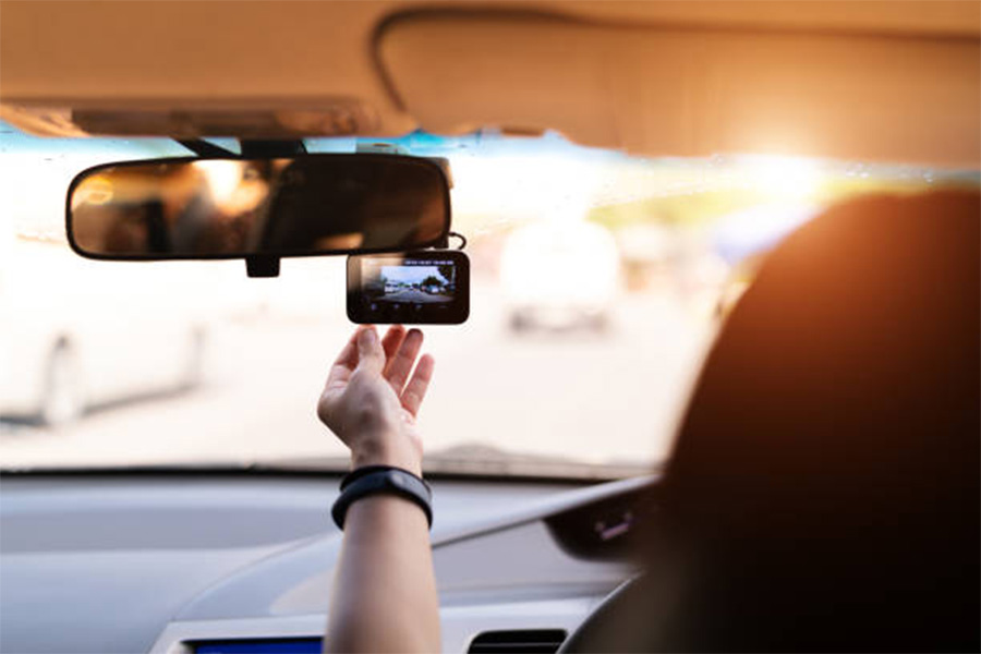 Dash camera on front windscreen being used by driver