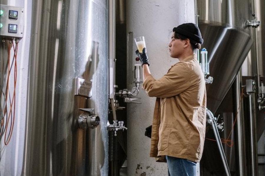 Employee testing a beverage inside a food processing facility