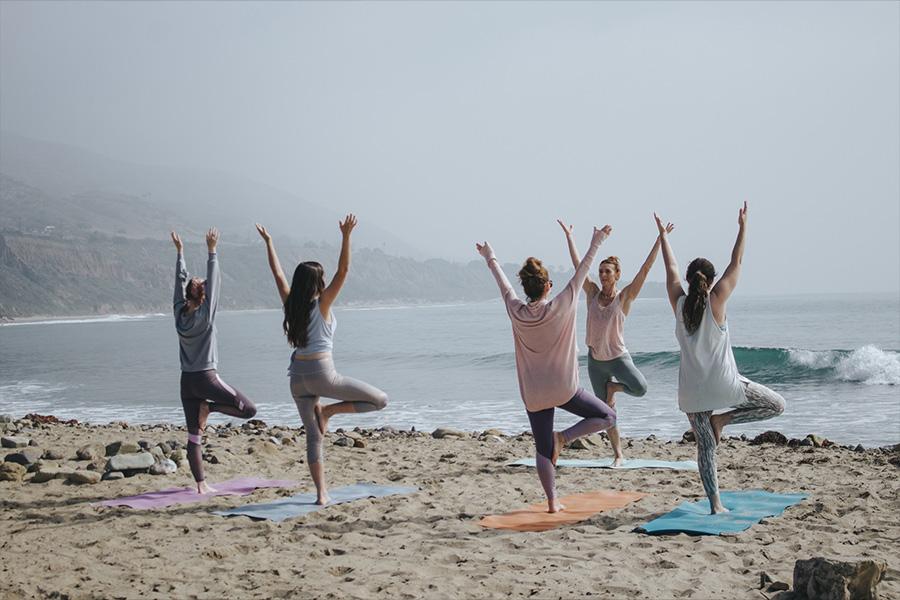 groupe pratiquant le yoga ensemble sur la plage