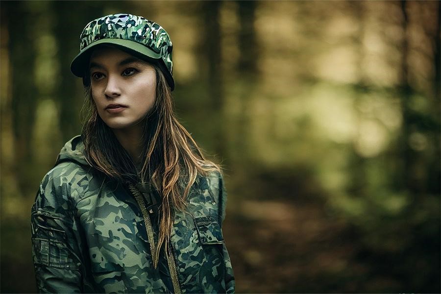 Signora che indossa uno snapback e una giacca mimetici