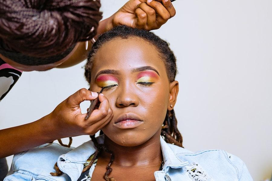 Maquilladora peinando el rostro de una mujer