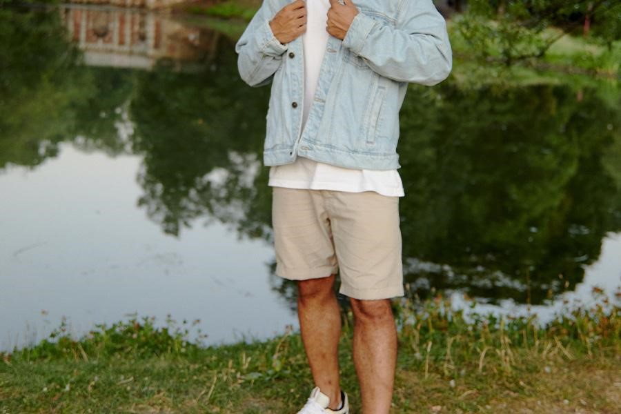 Man by the water in light brown shorts