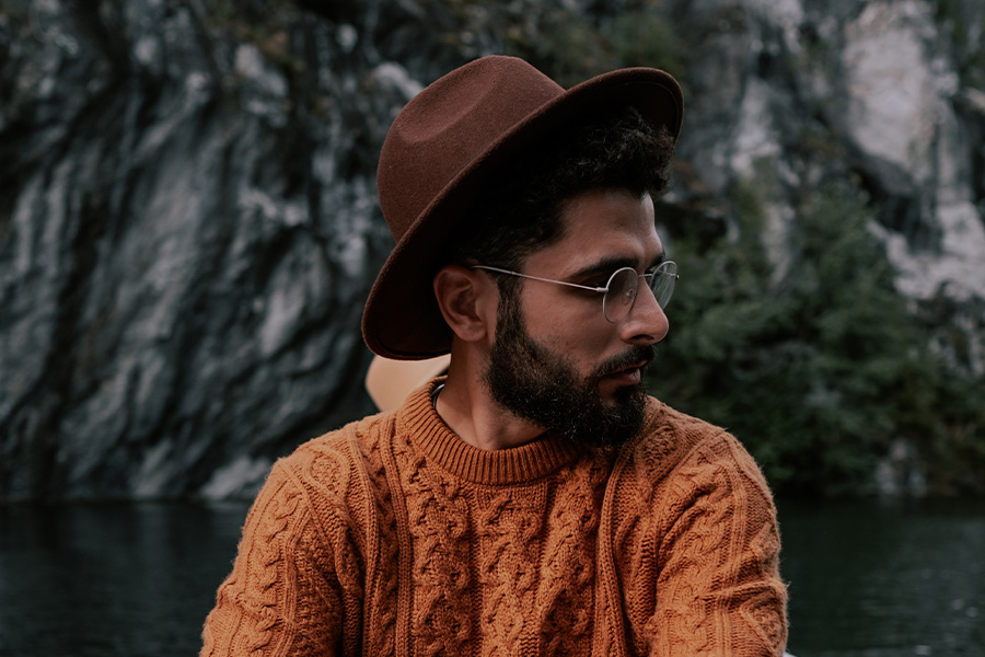 Homme dans un chapeau marron de style canotier au bord d'un lac