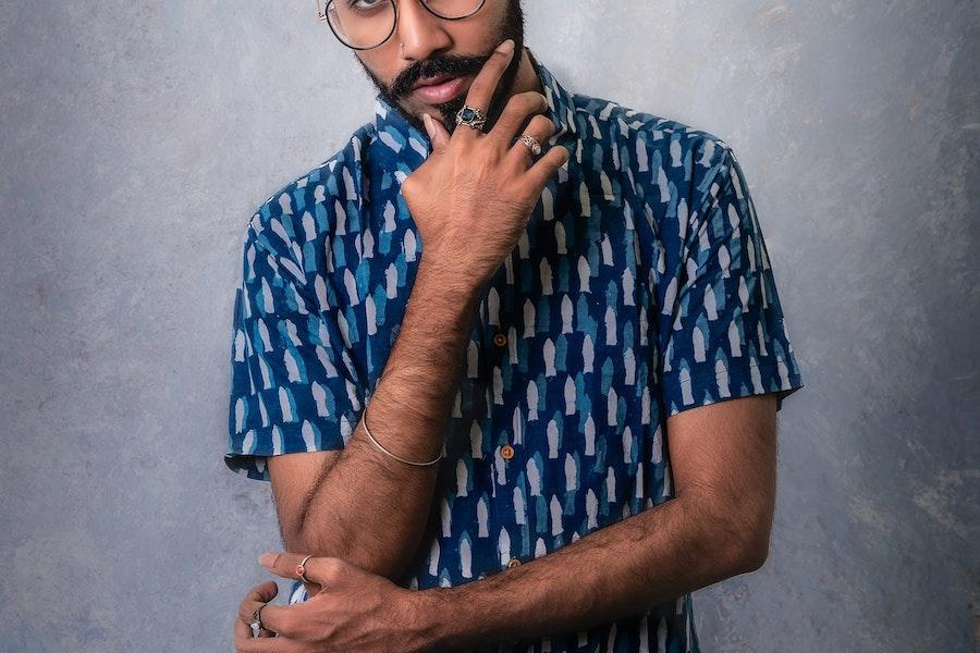 homem posando com uma camisa azul resort