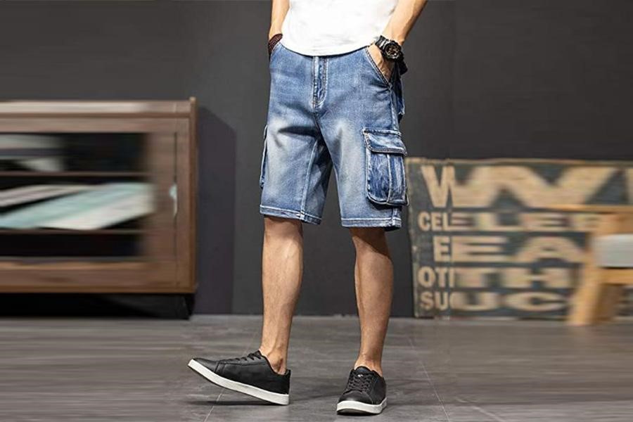 Mann posiert mit gewaschenen Denim-Cargo-Shorts