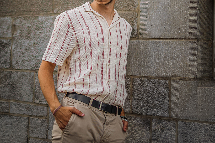 uomo appoggiato al muro con una camicia banale oversize