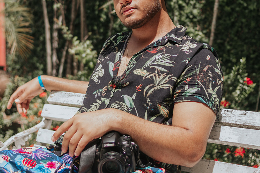 homem sentado em um banco com uma camisa preta resort