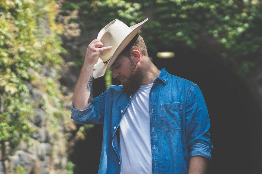 Uomo che colpisce una posa occidentale in un cappello da cowboy Bangora