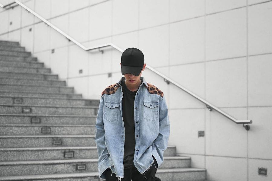 hombre vestido con una chaqueta de mezclilla y un sombrero de camión negro