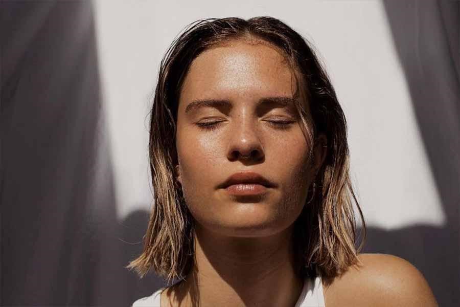 Modelo con cabello mojado y piel brillante