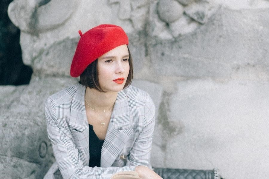 Femme assise portant un béret rouge