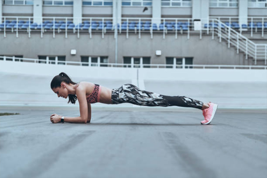 Mujer haciendo la plancha con calzas estampadas y sostén