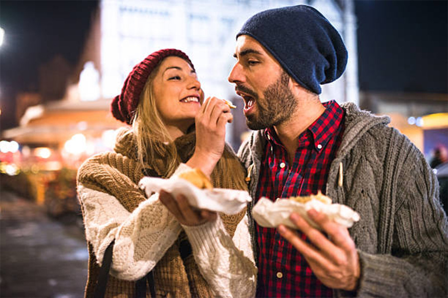 Wanita memberi makan pria keduanya memakai beanies