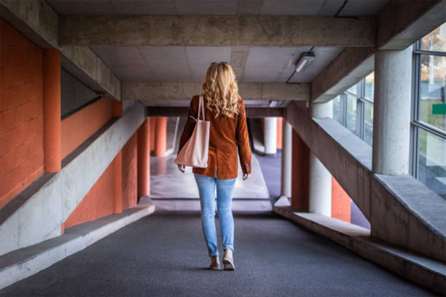 Femme en jeans et veste en velours côtelé marron dans un garage de stationnement