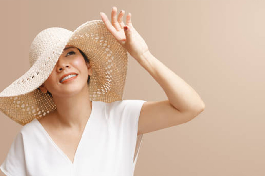 Woman in white shirt wearing a large sun hat