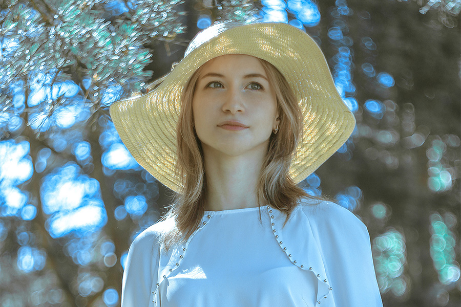 Donna che posa in un cappello da spiaggia floscio