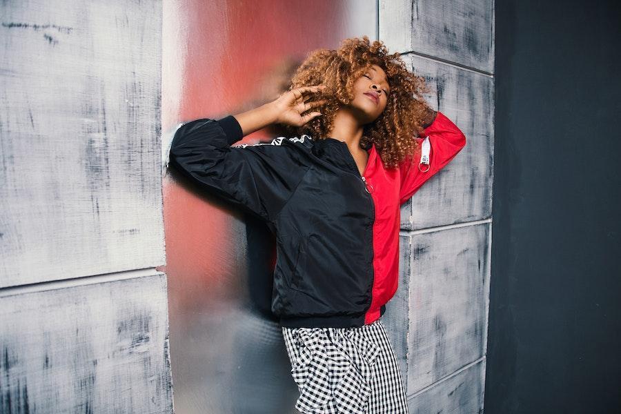 Femme posant avec un blouson rouge et noir