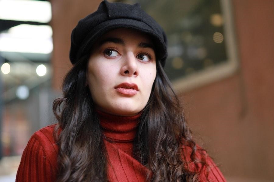 Femme berçant un chapeau d'écolier noir