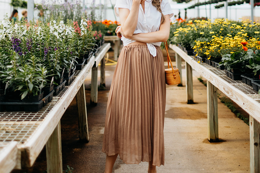 Frau steht in einem Garten mit braunem Boho-Rock