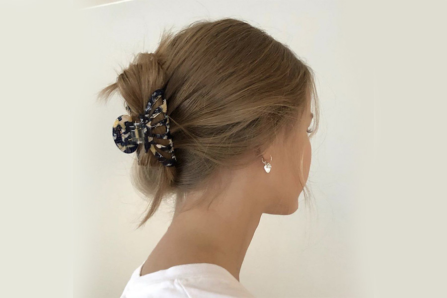 mujer peinando el cabello con una pinza para el cabello