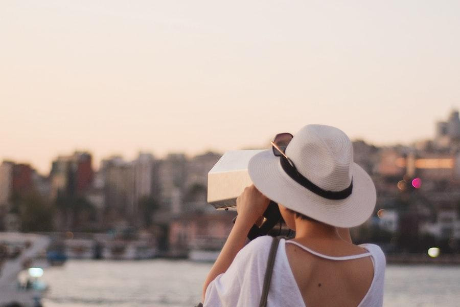 Donna che scatta foto con un cappello di paglia panama