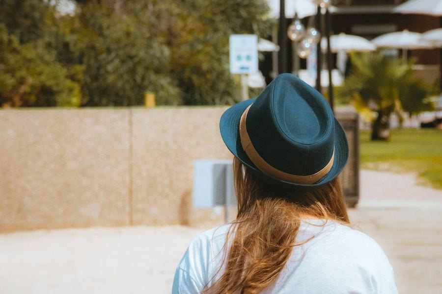 Femme portant un fedora noir avec une bande dorée